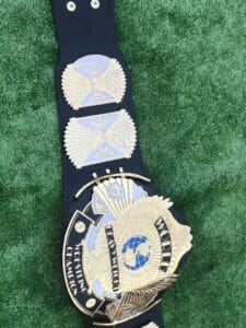 Close view of premium black leather strap on WWF Winged Eagle championship belt. Features hand-tooled pattern, snap fasteners on both ends, and flexible material for easy wear. Available in genuine or PU leather options.