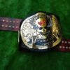Front view of WWF Smoking Skull Championship Belt showing central skull plate with smoke effects, gold finish, and black leather strap