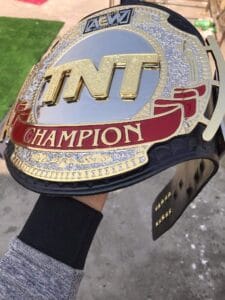 AEW TNT Replica Belt close plate – red champion banner gold silver etching detail