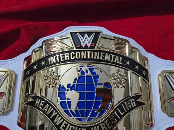 Close-up detail of WWE Intercontinental Championship Belt showing 4mm zinc buckle engraving, gold plating texture, leather stitching, and USA quality