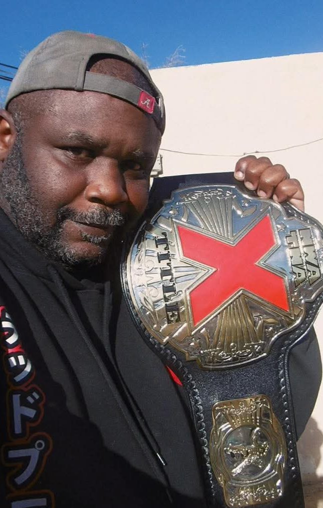 USA man taking or carrying the X title belt on his shoulder