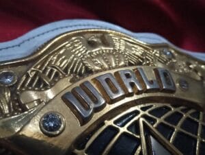 Close-up of WWE Women's World Heavyweight Championship replica belt center plate with gold engraving acrylic rhinestones and World Champion text